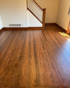 hardwood floors in an empty room facing staircase