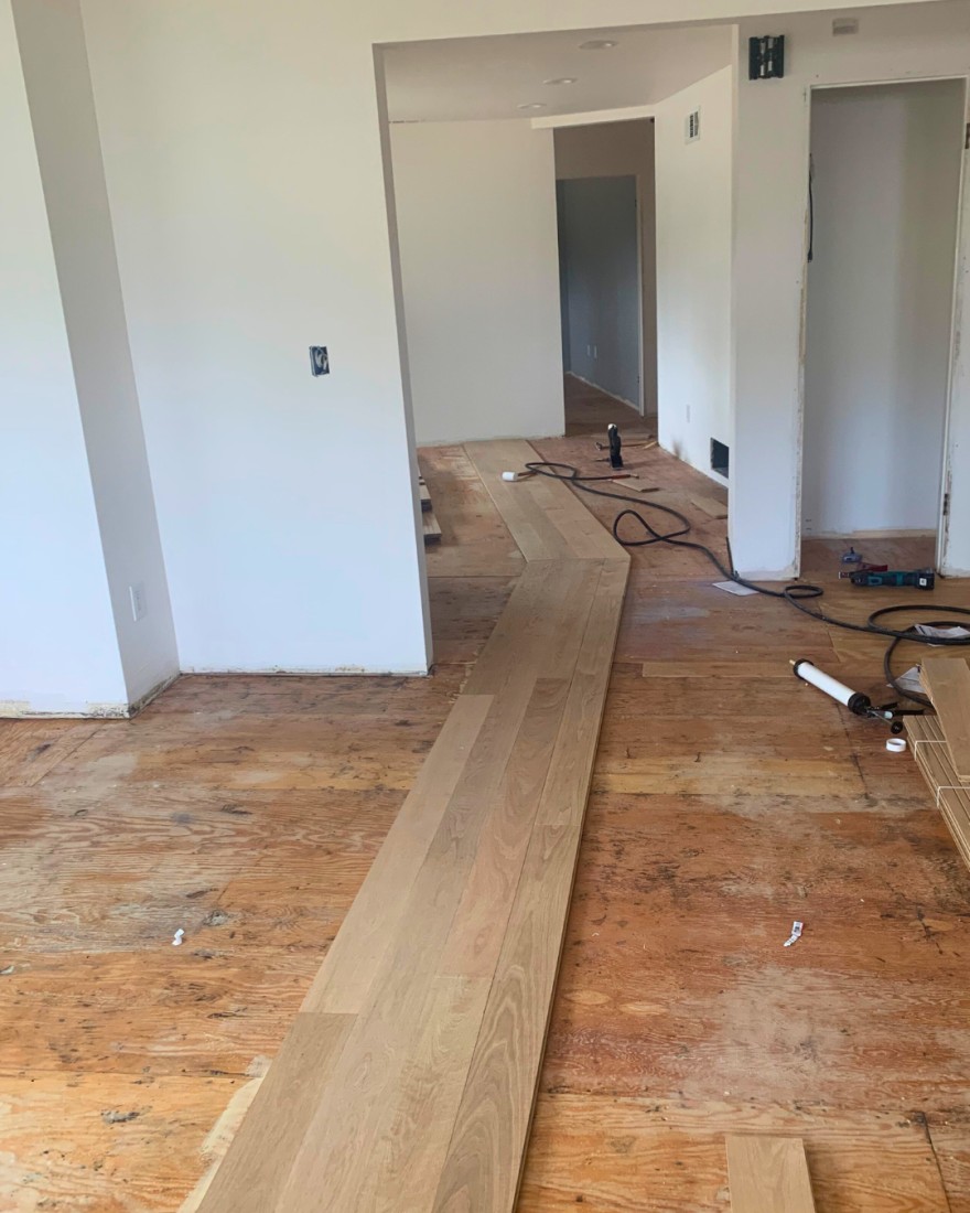 Installing 5 inch wide white oak floors at an angle inside of a home located in South Bend Indiana.