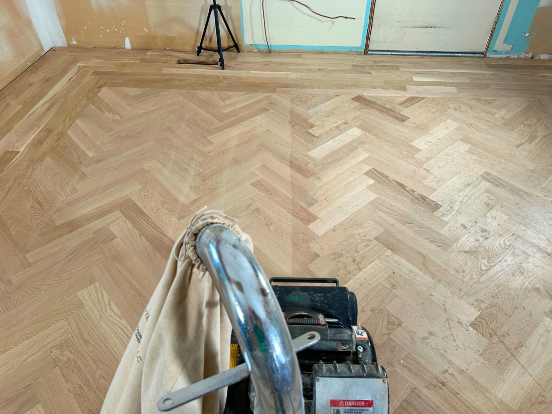 Sanding a newly installed white oak herringbone floor located in St. Joseph, Michigan.