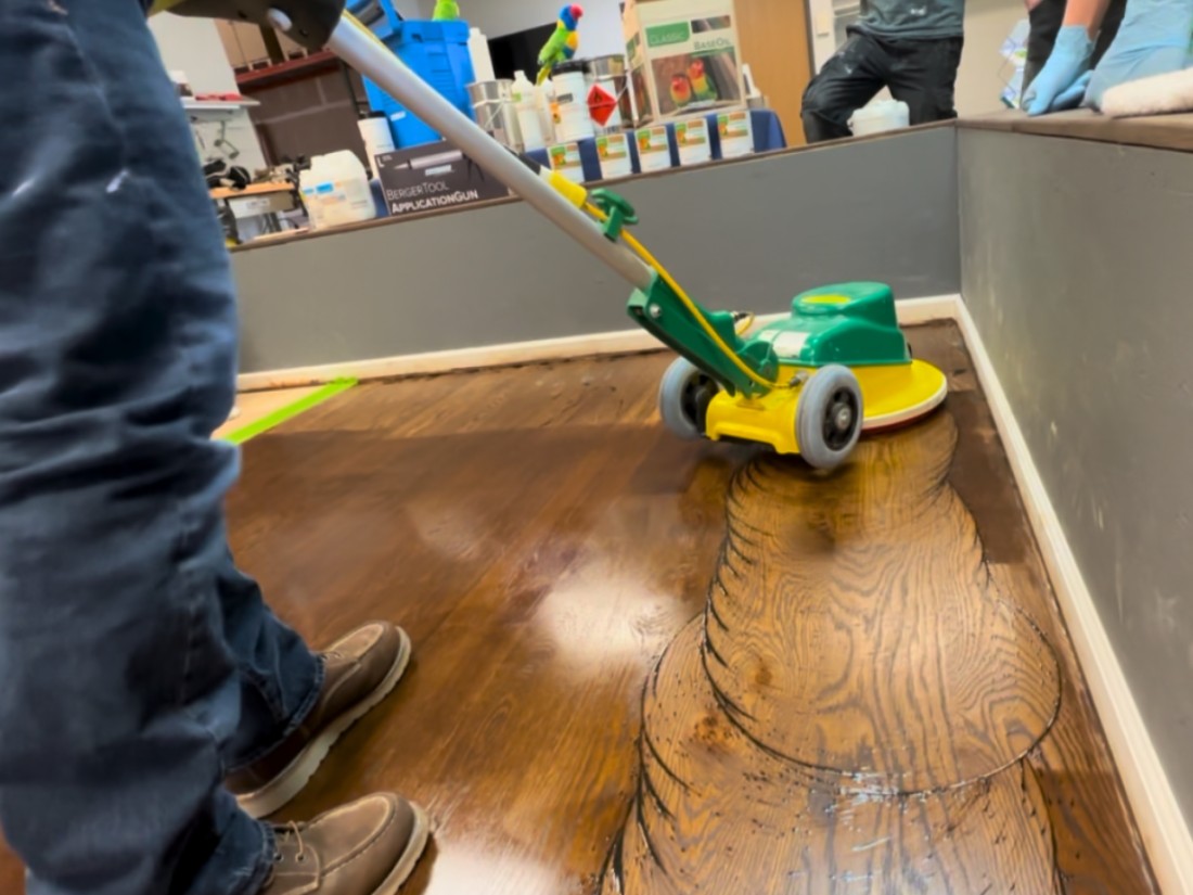 A buffer applying a brown stain to a white oak hardwood floor in South Bend, Indiana. 